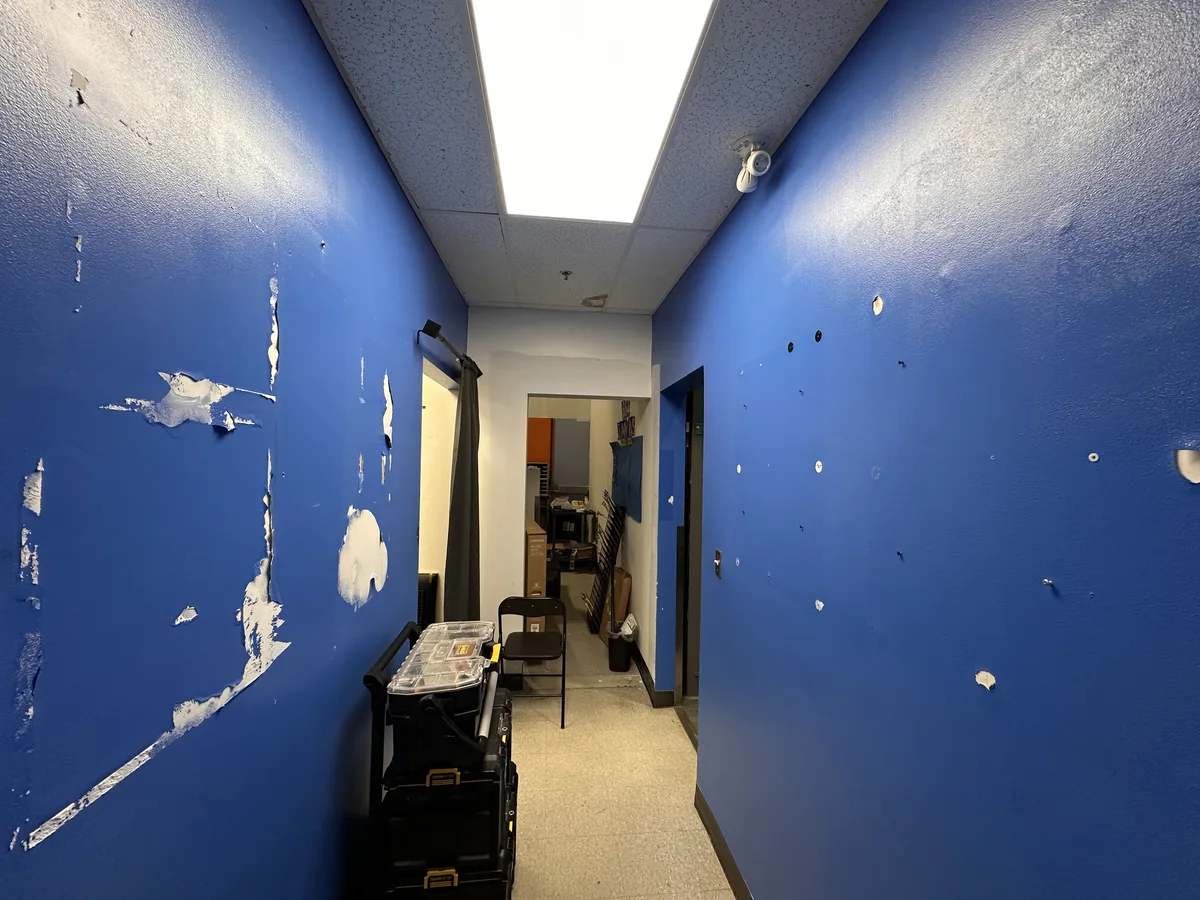 Commercial hallway with dark blue walls before repainting