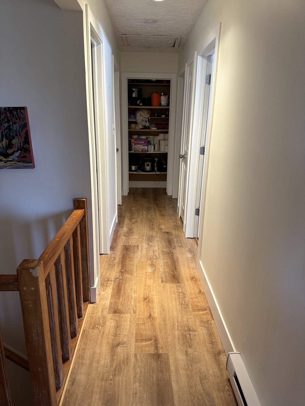 Hallway finished in honey-toned vinyl plank flooring