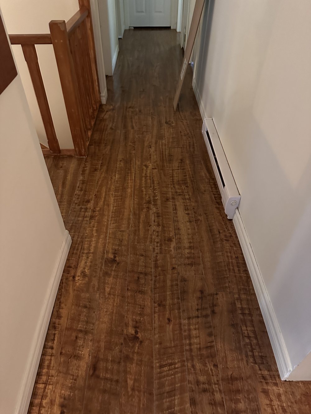 Hallway with a worn scratched floor before flooring