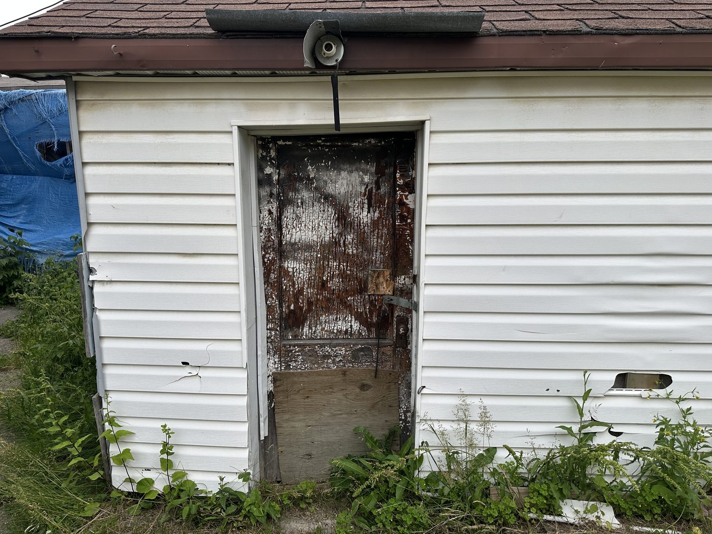 Damaged side garage door before replacement