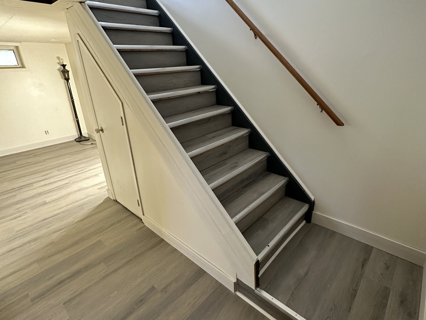 Stairs and floor after - new LVP flooring, baseboards and trim